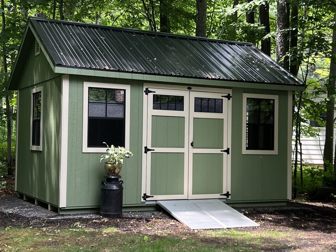 artichoke 10x14 chalet shed in Warsaw NY with Khaki Trim, black windows, a black metal roof, and an aluminum ramp